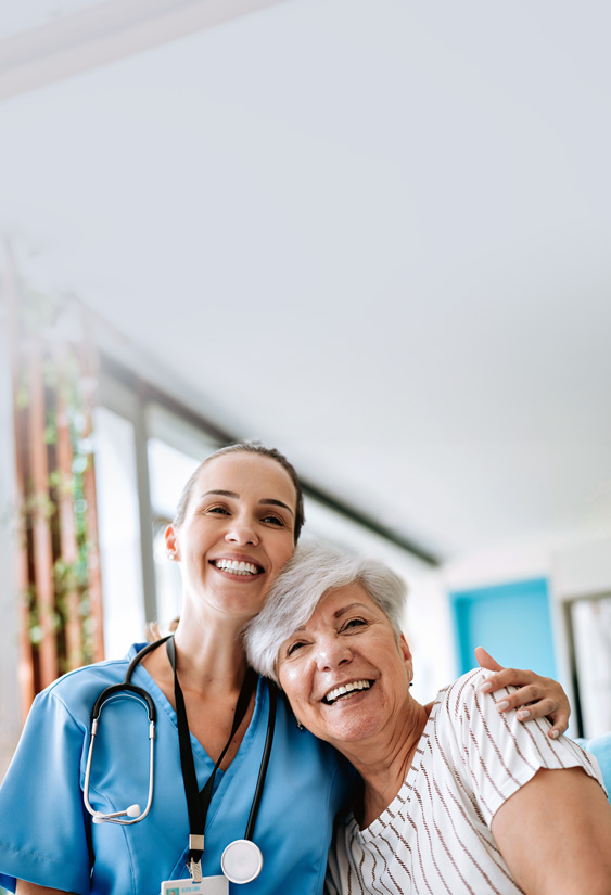 Nurse and patient embracing each other smiling