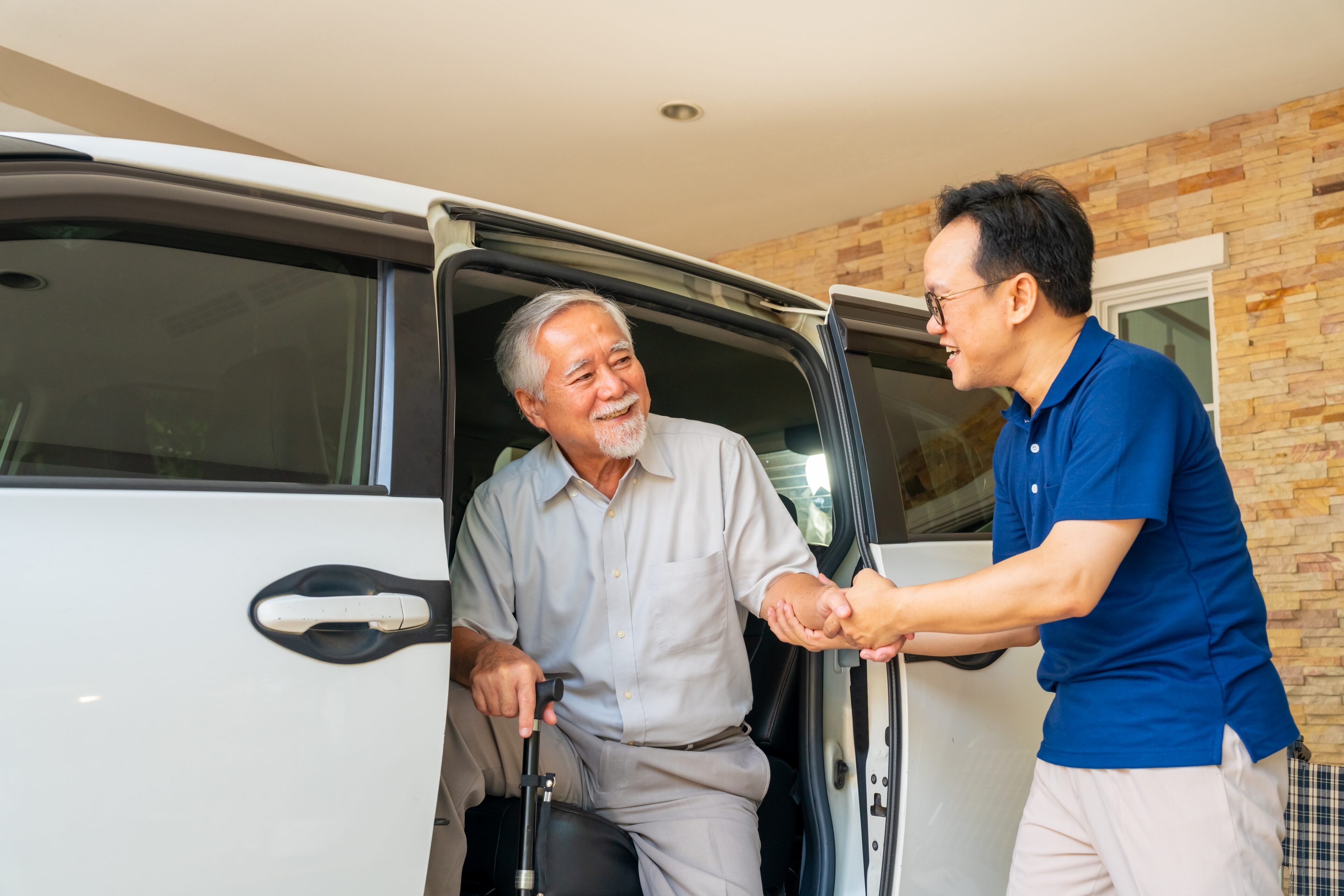 a care coordinator assisting a patient out of a car