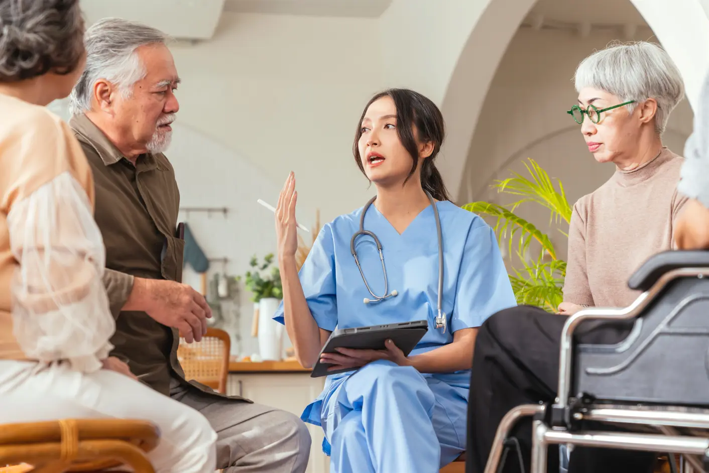 A licensed clinician explaining to a patient and caregivers how an effective care plan can help combat hospital readmissions.