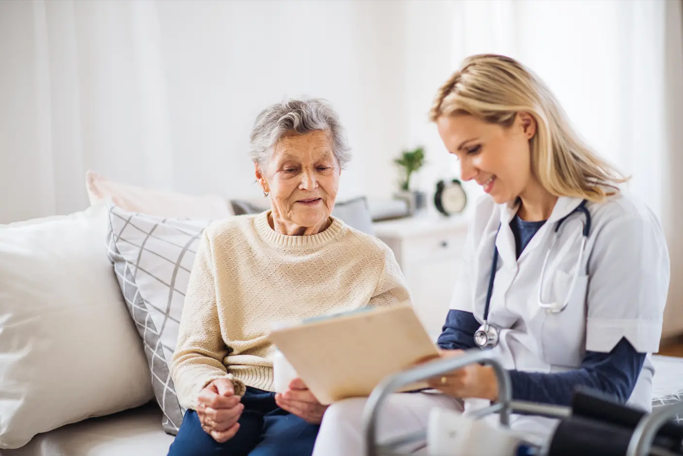 A clinician and a patient reviewing paper work together at an in-home visit.